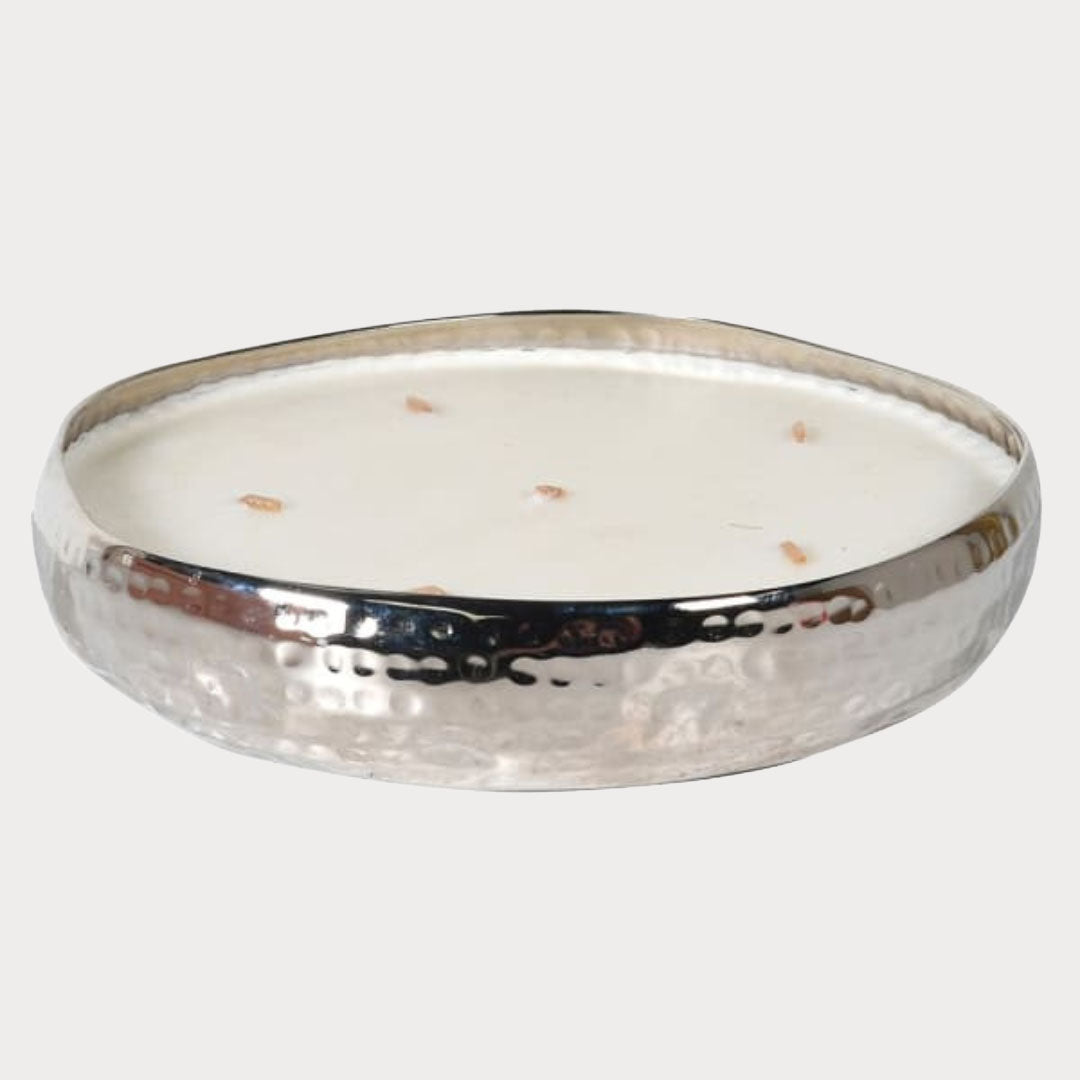 Tuberose Scented Candle lit, casting a warm glow in a cozy living room setting.